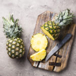1-2 Taste IFF Pineapple Culinary displayed as fresh pineapples and slices on wooden board with knife