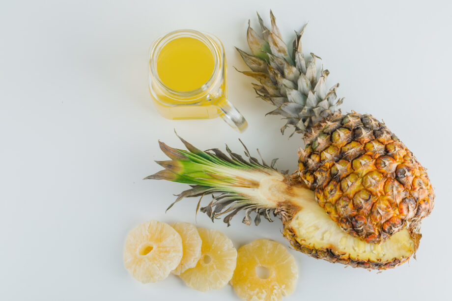 Pineapple with juice, candied rings on white background, flat lay.