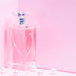 1-2 Taste IFF - Pearl Drop Fragrance displayed in a pink heart-engraved glass bottle surrounded by pearls on a soft pink background