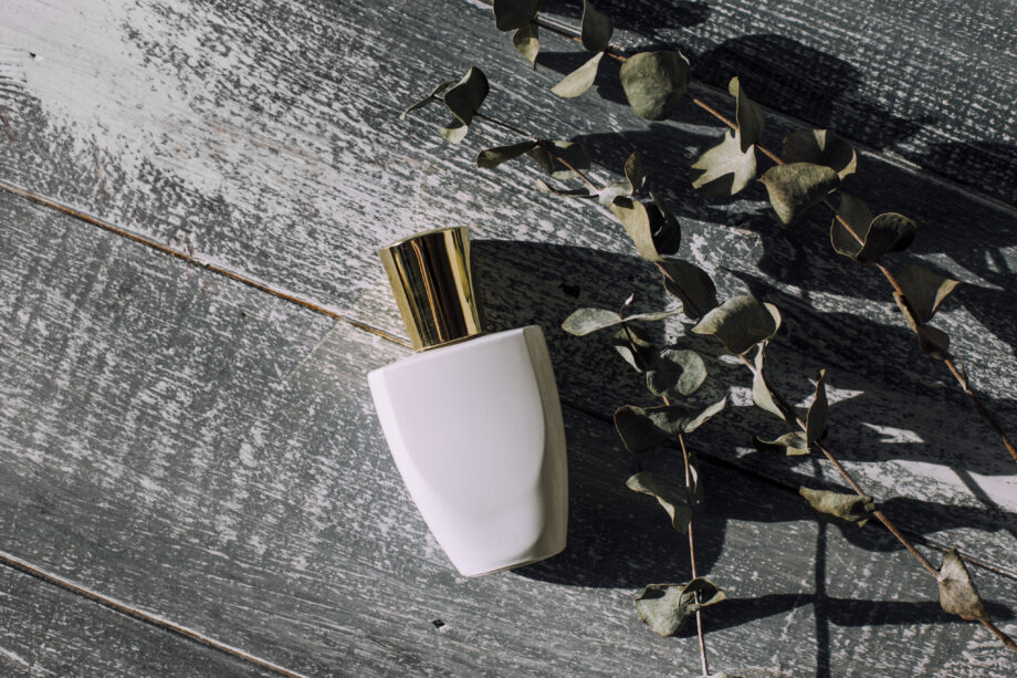 white-perfume-bottle-light-background