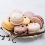 1-2 Taste Aroma INC - Vanilla Flavour Powder - O20206 shown as assorted vanilla and chocolate macarons on a plate with vanilla beans and chocolate chips