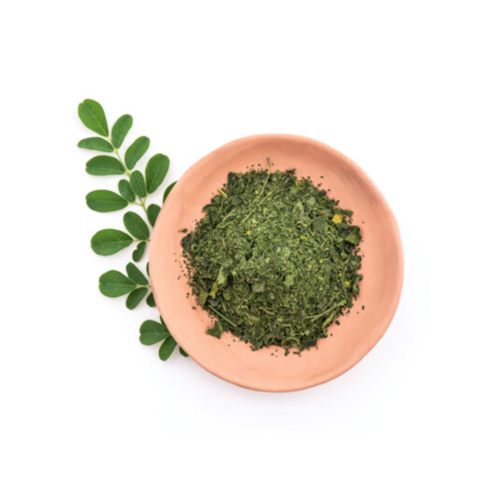 1-2 Taste Africrops - Organic Moringa Leaves - 040110011 displayed as dried green leaf flakes in clay bowl with fresh moringa sprig