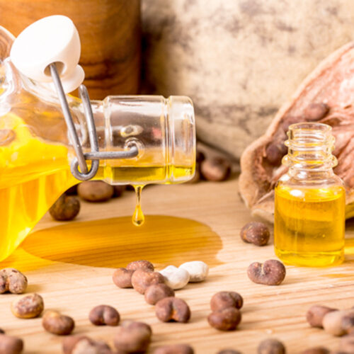 1-2 Taste Africrops - Organic Baobab Oil - 340240051 in glass bottles with golden-yellow oil and baobab seeds on wooden surface