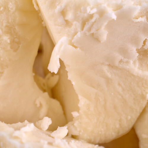 1-2 Taste JS Cocoa - Deodorized Cocoa Butter VELVET™ UTZ MB shown in a close-up of creamy, pale cocoa butter chunks with a smooth and flaky texture