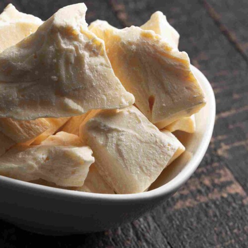1-2 Taste JS Cocoa - Refined and deodorized Cocoa Butter OLYMPUS™ presented as light ivory cocoa butter chunks in a white bowl on a dark wooden surface