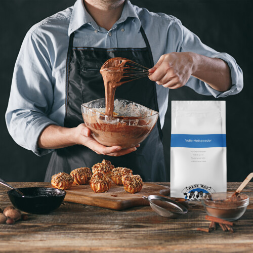 Best Way Ingredients - Full Cream Milk Powder Instant shown as baker preparing chocolate batter with product pouch placed beside freshly baked muffins in a rustic kitchen setting