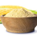 1-2 Taste FiberSMART Corn Powder 90% in a wooden bowl beside fresh corn