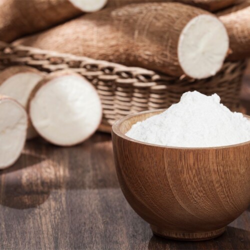 1-2 Taste FiberSMART Organic Tapioca Powder 90% in a wooden bowl with fresh cassava roots in the background