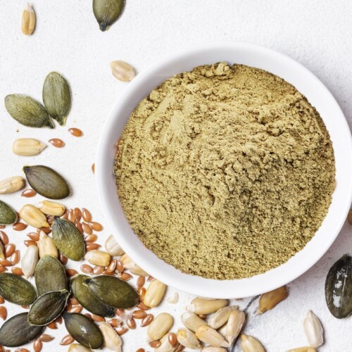 1-2 Taste ProteoSMART Vegan Protein Blend VIE powder in a wooden bowl
