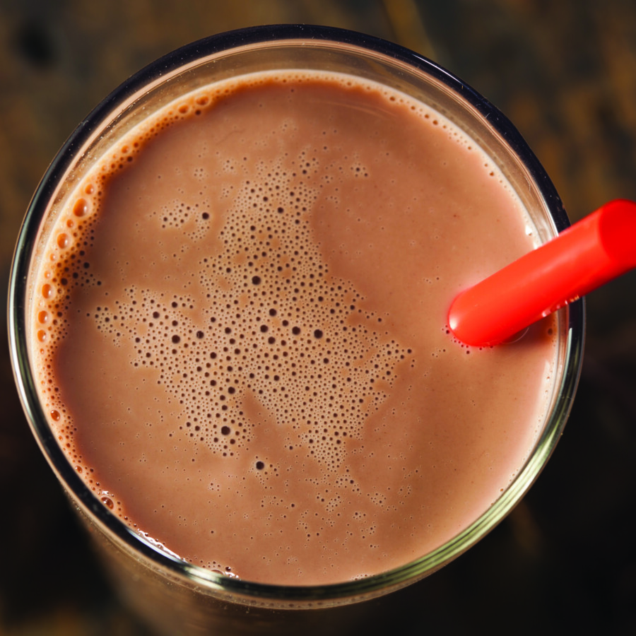 Chocolate milk on a glass with red straw