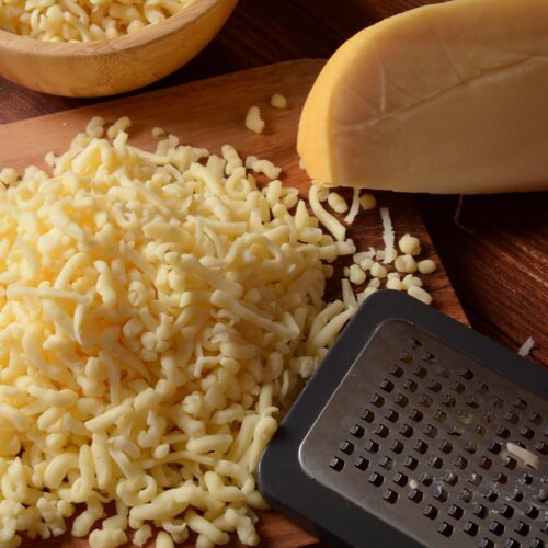 1-2 Taste Trigona - Gouda Young Grated on wooden board with metal grater and cheese block
