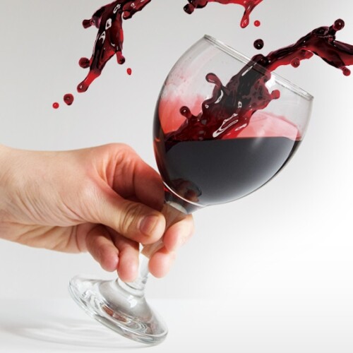 1-2 Taste Nutracevit - Organic haskap berry juice NFC splashing into tilted wine glass held by hand