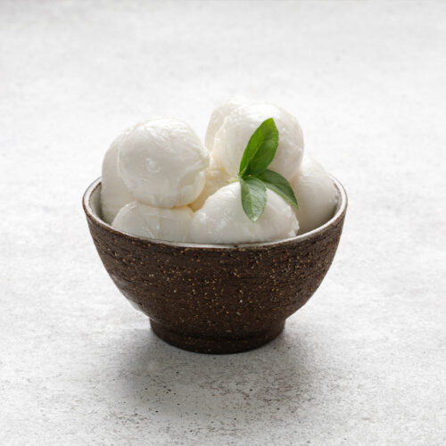 1-2 Taste Trigona - Buffalo Mozzarella Small in dark ceramic bowl with fresh green leaf
