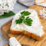 1-2 Taste Trigona - Cream Cheese on toast with fresh parsley garnish, creamy texture on wooden board
