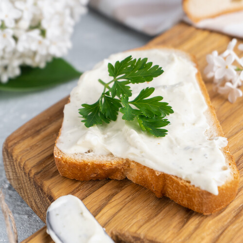 1-2 Taste Trigona - Cream Cheese on toast with fresh parsley garnish, creamy texture on wooden board