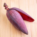 1-2 Taste Trigona - Banana Blossom as vibrant purple-red bloom on wooden surface