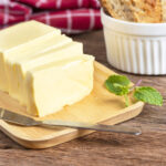 1-2 Taste Trigona - Sweet Cream Butter sliced on wooden board with mint garnish