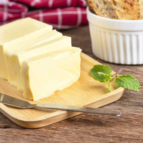 1-2 Taste Trigona - Sweet Cream Butter sliced on wooden board with mint garnish