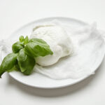 1-2 Taste Trigona - Buffalo Mozzarella shown on white plate with fresh basil