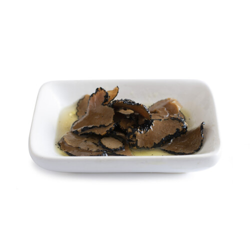 Trufo – Black Summer Truffle Carpaccio in Brine displayed on a white rectangular dish, featuring thin, delicate slices of truffle soaked in a light brine