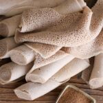 1-2 Taste Blonk Quality Ingredients - Brown Teff Flour for Injera shown as traditional Ethiopian Injera rolls made from teff flour on rustic wooden surface