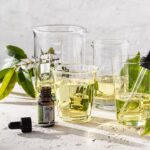 Lemon Myrtle 100% Essential Oil in dropper bottle beside measuring beakers and leaves ,USDA Organic certified