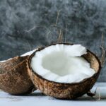 1-2 Taste Aroma INC - Coconut Flavour - O20234 shown as Fresh halved coconut with white flesh on a grey background