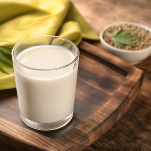 1-2 Taste Vegan Stock - Raw Hemp Milk Base - RHSPEU100.A9 shown as a glass of creamy hemp milk on wooden tray with raw hemp seeds in background