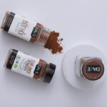 1-2 Taste Dace - Organic Star Anise Powder in spice jars with scattered powder on white background